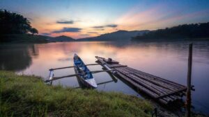 Pemandangan indah Waduk Sermo dengan air yang tenang dan dikelilingi perbukitan hijau