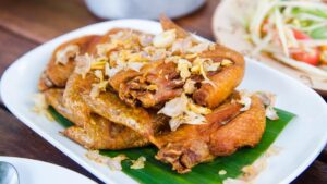 Ayam Bawang Putih Gurih: Potongan ayam goreng renyah dengan tumisan bawang putih harum, disajikan dengan nasi hangat untuk sensasi rasa gurih dan lezat